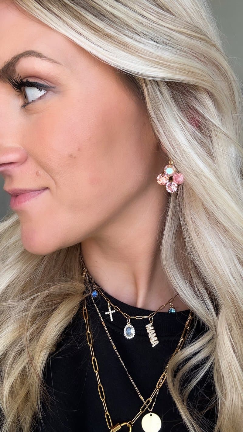 Maria wearing pink crystal studs and mama necklace in profile