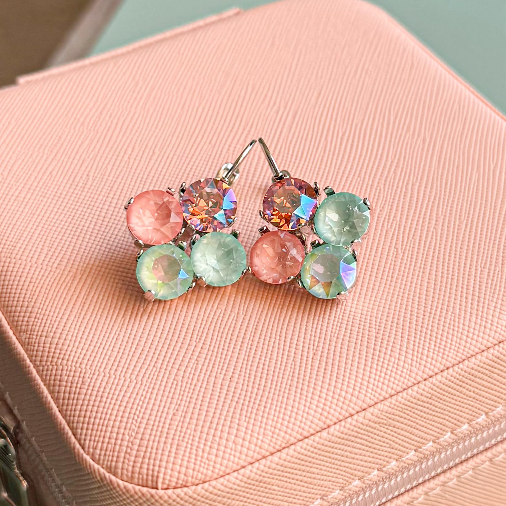 Pastel pink and mint multi-crystal cluster earrings on pink jewelry box